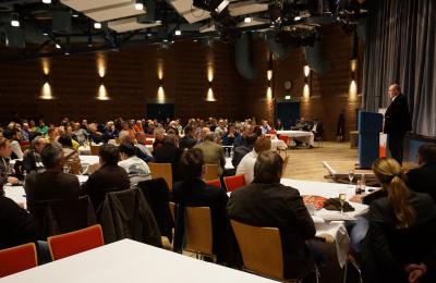 Redner Matthias Maurer, zahlreiche Teilnehmer an den Tischen