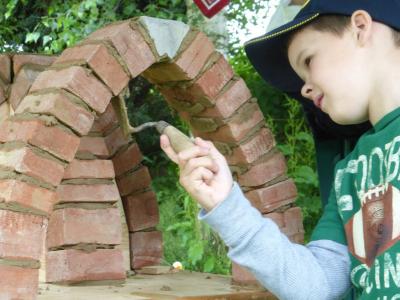 Junge beim Rundbogen-Mauern Junge beim Rundbogen-Mauern