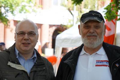 Zwei Personen: André Buschmann und Frank Schlanske, Letzterer im T-Shirt mit der Aufschrift &quot;Arbeiter-Fotografen&quot; und Cappy.