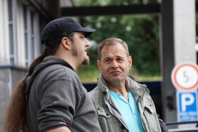 Zwei Männer - Harry Gosch seitlich mit Cappy und langem Zopf, daneben André Grundmann in Jacke und hellblauem T-Shirt