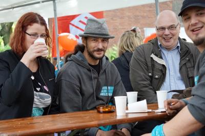 Mehrere jüngere BAU-Mitglieder am Biertisch, Blick Richtung Kamera