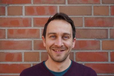 Portraitaufnahme von Alexander Kahl vor einer gemauerten Wand. Portraitaufnahme von Alexander Kahl vor einer gemauerten Wand.