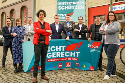Hamburgs DGB-Vorsitzende Tanja Chawla im Vordergrund, dahinter acht Vertreter:innen der Einzelgewerkschaften mit einem blauen Banner, Aufschrift: "Recht Gerecht". Hamburgs DGB-Vorsitzende Tanja Chawla im Vordergrund, dahinter acht Vertreter:innen der Einzelgewerkschaften mit einem blauen Banner, Aufschrift: "Recht Gerecht".