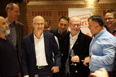 Hamburgs Bürgermeister Peter Tschentscher und der damalige Vorsitzende der IG BAU Hamburg, Matthias Maurer, umringt von einem halben Dutzend Kolleg:innen der IG BAU. Alle lachen. Hamburgs Bürgermeister Peter Tschentscher und der damalige Vorsitzende der IG BAU Hamburg, Matthias Maurer, umringt von einem halben Dutzend Kolleg:innen der IG BAU. Alle lachen.